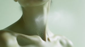 flacone di profumo con piante aromatiche su sfondo verde salvia