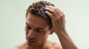 uomo applica olio naturale per capelli secchi