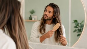 Uomo si prende cura delle sue extension capelli naturali a casa