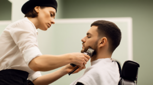 Barbiera al lavoro mentre rifinisce la barba a un cliente